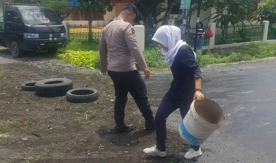 Personel Polsek Siantar Utara Bersihkan Minyak Goreng Tumpah Di Jalan 