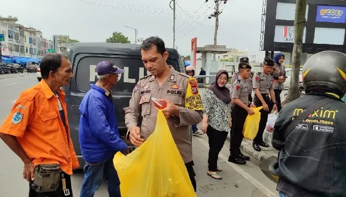 Personel Polsek Medan Baru Bagikan Nasi Bungkus ke Pengguna Jalan