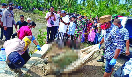 Petugas kepolisian bersama para medis meng-evakuasi mayat laki-laki yang ditemukan dalamkarung di Sungai Desa Jeungki, Kec. PeureulakTimur, Aceh Timur, Selasa (20/7). Beritasore/ist
