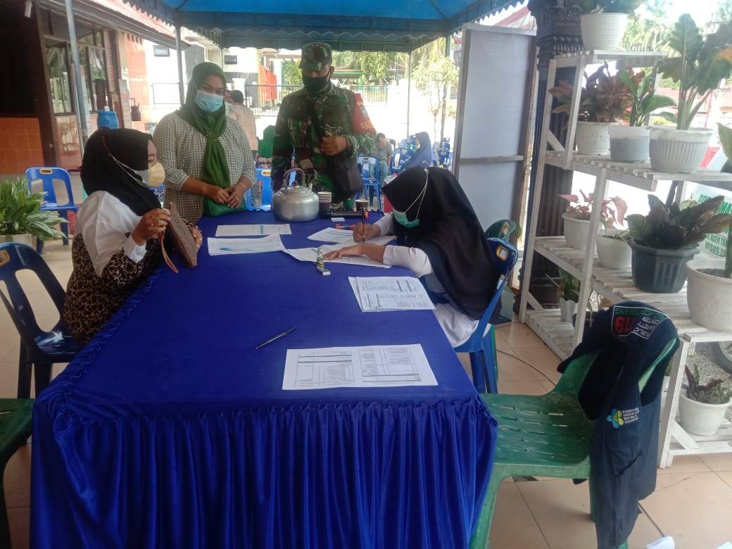 Babinsa Koramil 07/Kejuruan Muda, Serda LO Situmorang saat mendampingi warga yang vaksin di Puskesmas Kejuruan Muda, Aceh Tamiang. Beritasore/hendra