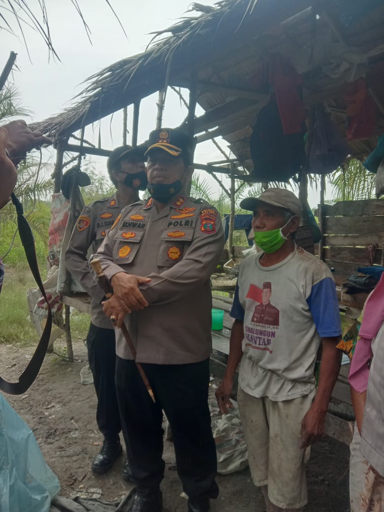 Kapolres ke-6 Batubara AKBP H.Ikhwan Lubis SH,MH pejuang Duafa tiba dikediaman Atan Sinaga (89) yang tinggal dirumah reot didusun VI Desa Tali Air Permai Kec.Nibung Hangus Kab.Batubara Kamis (8/7-2021).beritasore/Alirsyah