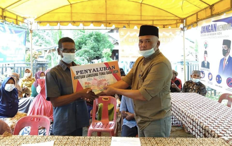 Datok Penghulu Kampung Mesjid Sei Yu Kecamatan Bendahara Syaiful Syahputra saat menyalurkan Bantuan Langsung Tunai Dana Desa kepada warga. Beritasore/ist