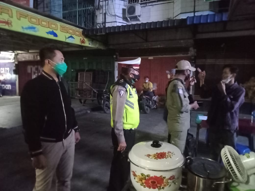 Kanit Lantas Polsek Medan Baru Iptu R.Situmorang yang di dampingi Kanit Reskrim Iptu Irwansyah Sitorus.SH MH melakukan penempelan himbauan PPKM di salah satu warung makan di Jalan Gatot Subroto.beritasore/ist