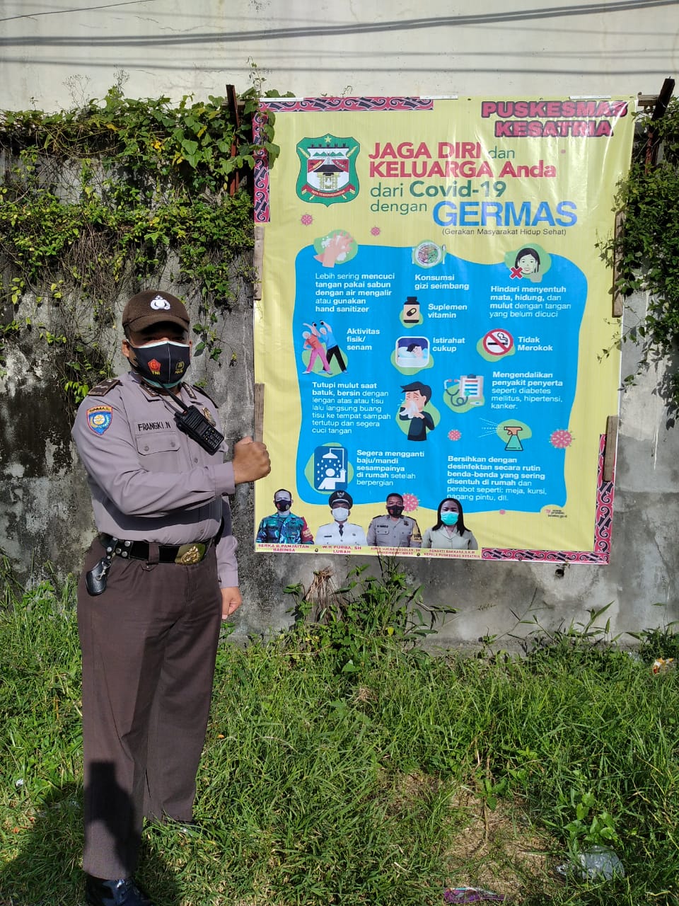 Bhabinkamtibmas kelurahan Siopat Suhu, kecamatan Siantar Timur, Aipda Untung JF Nainggolan memasang spanduk himbauan patuh protokol kesehatan. beritasore/Surati