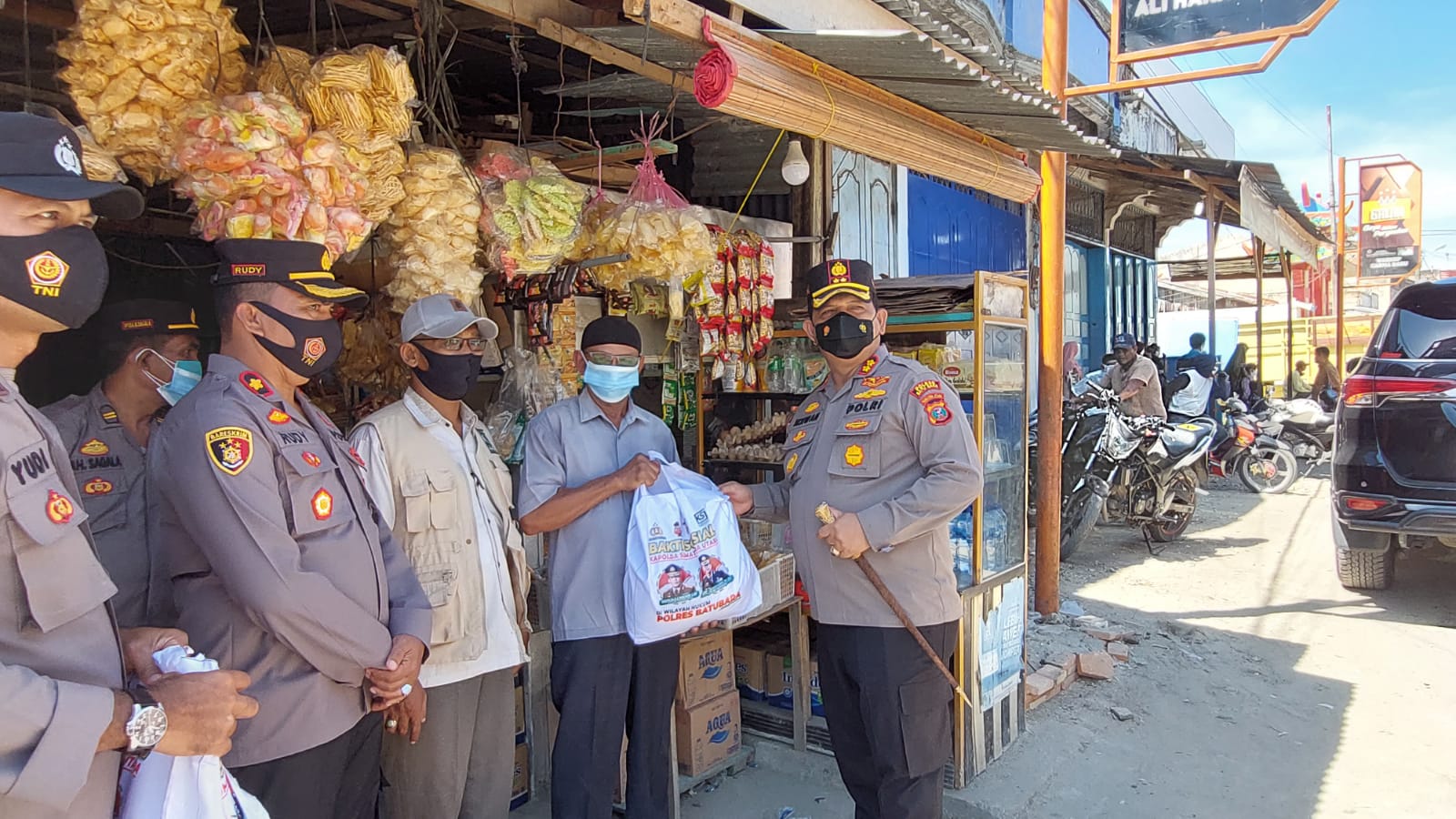 Kapolres Batubara AKBP H.Ikhwan Lubis SH,MH menyerahkan Baksos Kapoldasu kepada para pedagang asongan berjualan di emperan toko pinggir jalan Kota Tanjung Tiram warga pesisir Pantai Timur Sumatra Utara, Rabu (21/7/2021).beritasore/Alirsyah