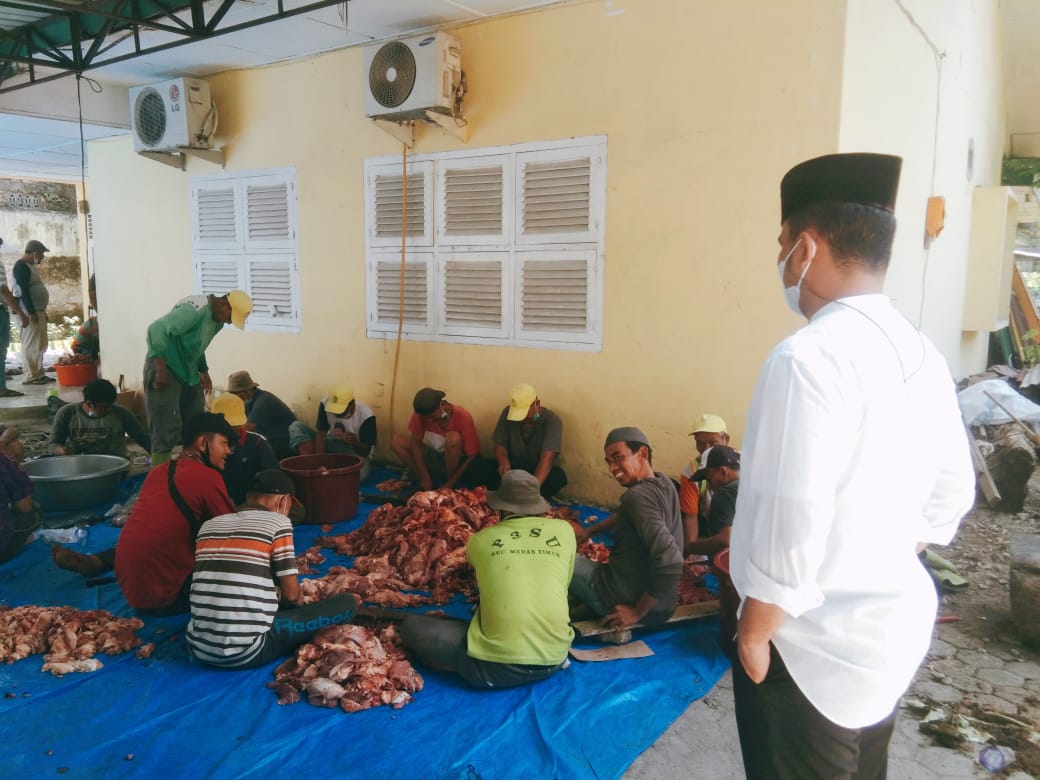 Camat Medan Timur Odi A Batubara S.STP menyaksikan penyincangan Hewan Qurban di halaman belakang kantor Camat Medan Timur. Rabu (21/7). Beritasore/Muslim Lubis