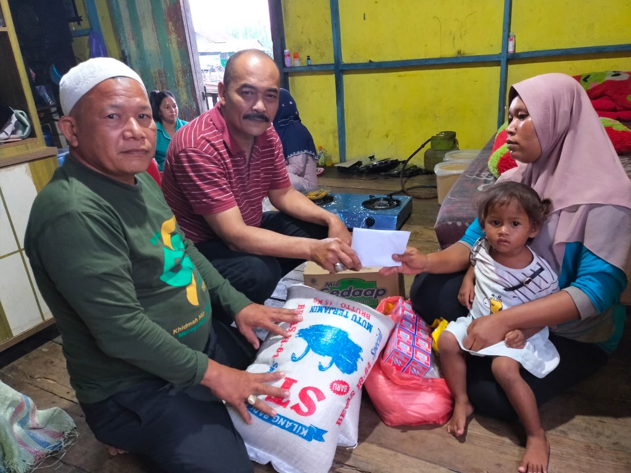 Ketua DPW PNTI Sumut Adhan Nur SE menyerahkan bantuan  kepada Dewi  istri  Gafaruddin, di kediaman korban Jl Pompa Air Kelurahan Sei Bilah Kec Sei Lepan Kab Langkat,  Jumat (30/7). beritasore/ist