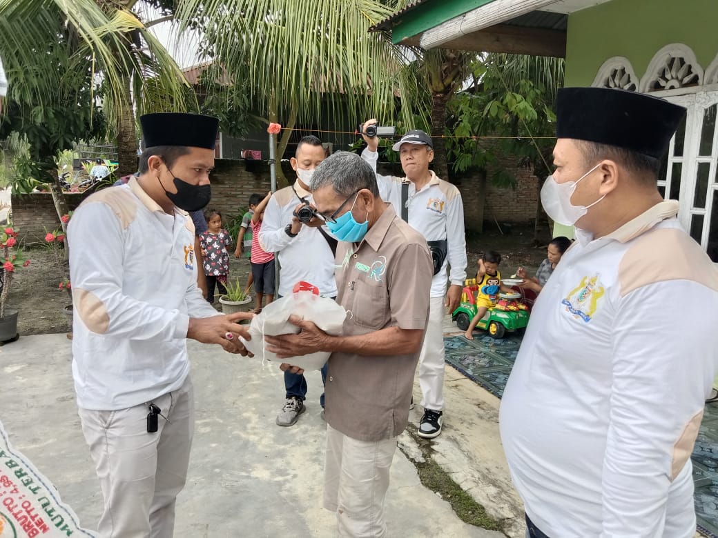 Koordinator Kadin Batubara Burhan berbagi kepadda warga Kampung Gereja Desa Simpang Dolok Kecamatan Datuk Limapuluh Kabupaten Batubara Sumatera Utara didampingi Loli Sastra, Kamis (4/11/2021). beritasore/Alirsyah