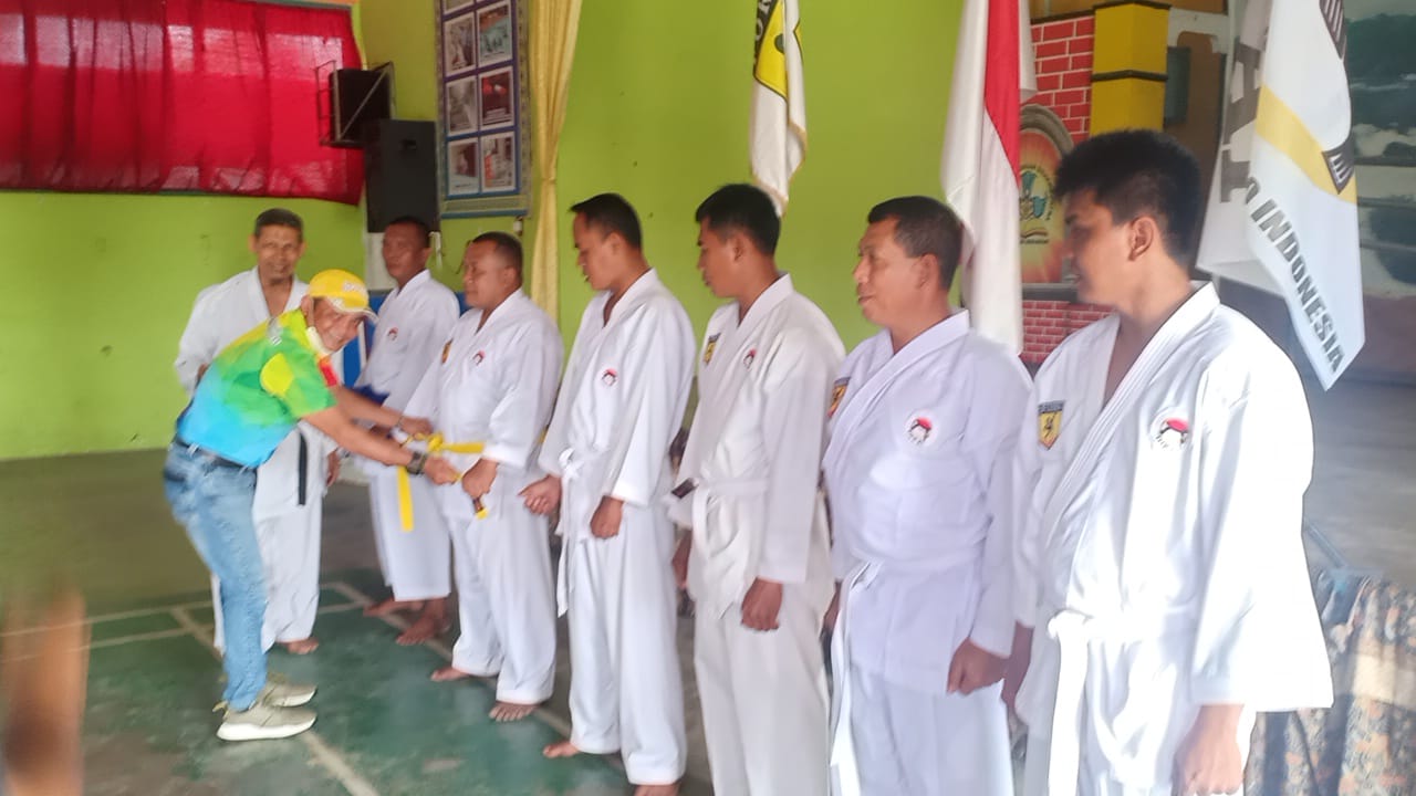 Pimpinan Pertamina RU II area Pangkalanbrandan M Natsir melakukan penyematan sabuk kepada peserta UKT yang naik tingkat di GOR SMA Dharna Patra P. Brandan,  Minggu (7/11) sore. beritasore/ist