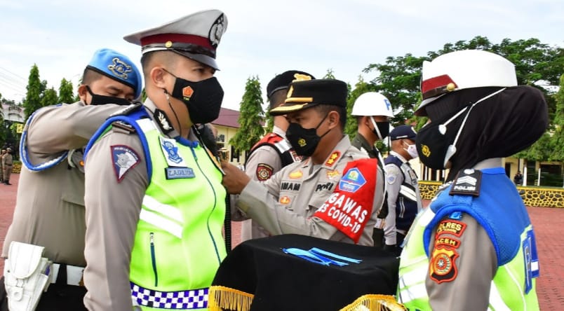 Kapolres Aceh Tamiang AKBP. Imam Asfali, S.I.K saat penyematan pita secara simbolis kepada perwakilan pasukan Apel. Beritasore/ist