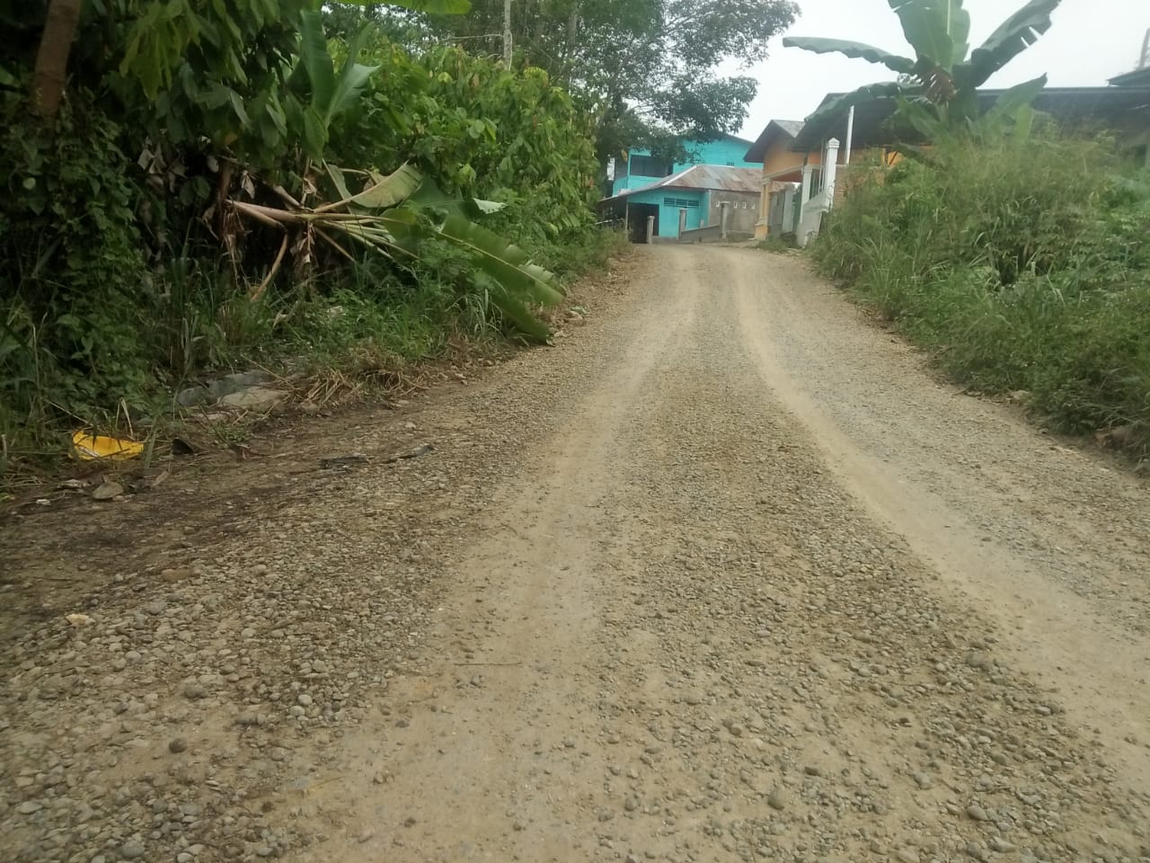 Material batu krikil dibadan jalan terlihat masih berserakan dan belum juga di aspal,Kamis (18/11). beritasore/Birong RT