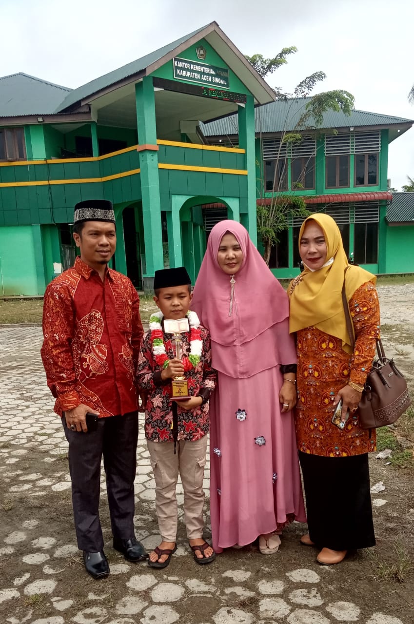 Alfan Ramadhan, Juara I Tilawah Putra pada ajang Pentas seni PAI ke-V provinsi Aceh didampingi kedua orang tua dan Kepala sekolah melakukan sesi photo usai penyambutan di halaman depan kantor Kemenag Singkil.beritasore/M.Zaelani Sidik