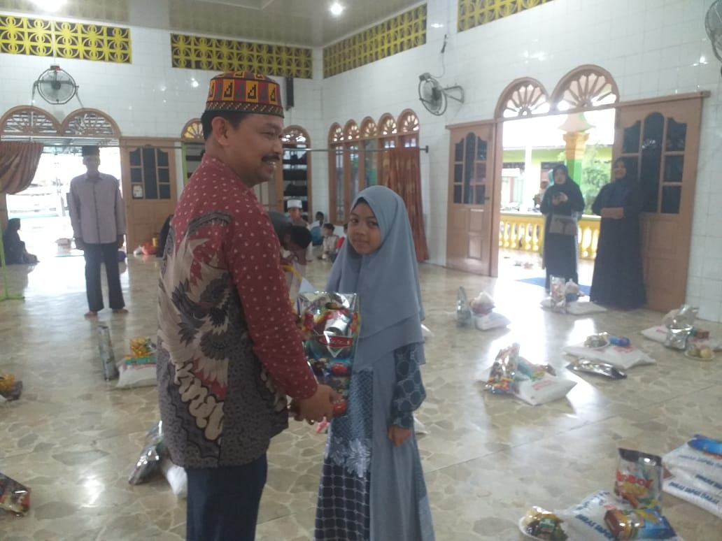 Wakil Ketua DPRK Aceh Tamiang, S H sedang menyantuni Anak Yatim bertempat di Masjid AN-NUR Kampung Perdamaian. beritasore/ist