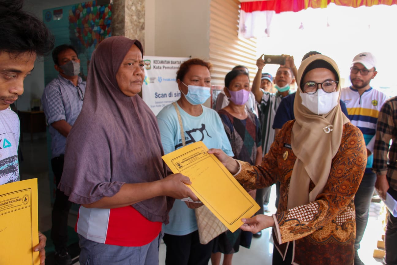 Pelaksana tugas walikota Pematang Siantar ,Susanti Dewayani menyerahkan bantuan kepada korban bencana alam angin puting beliung. beritasore/Surati