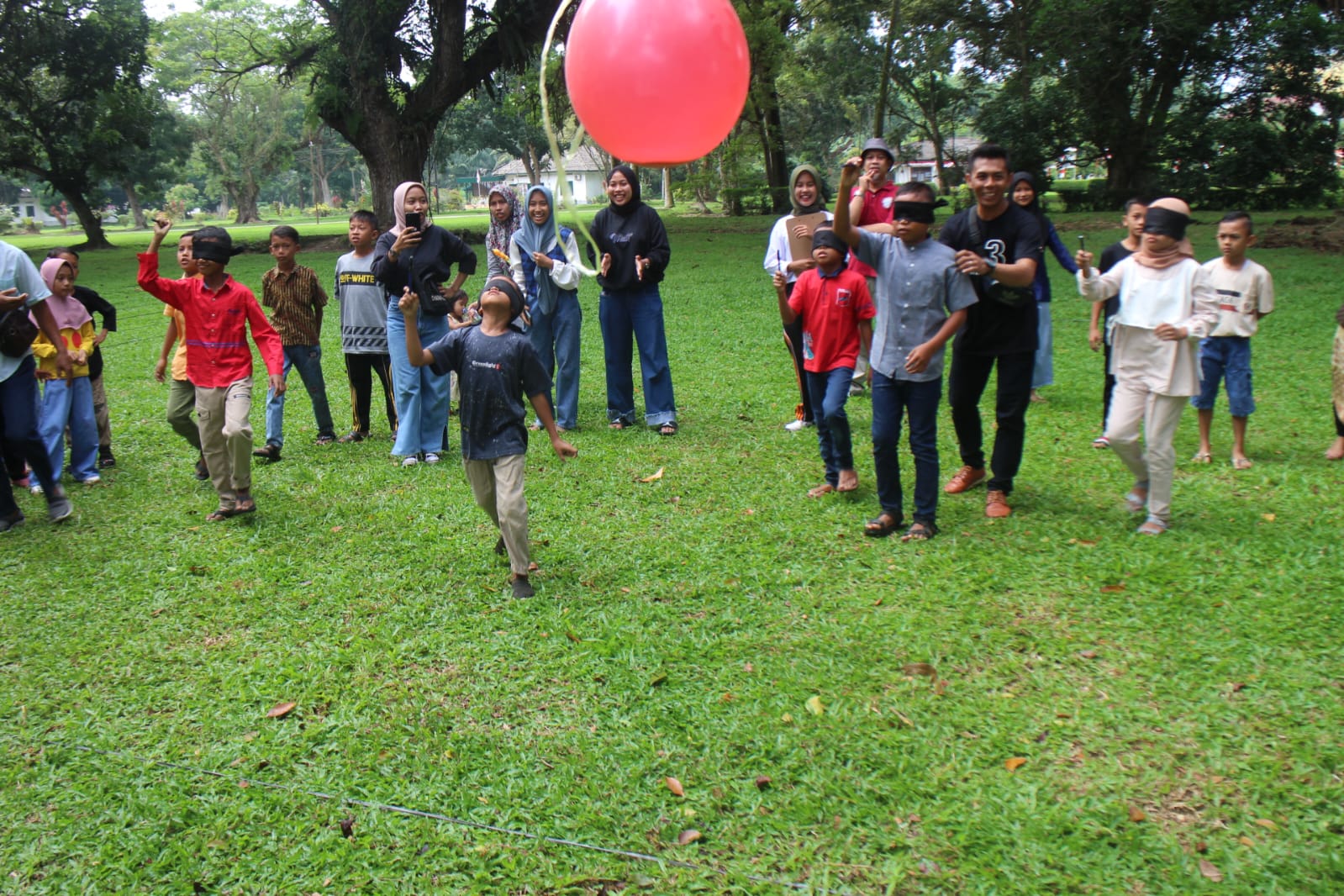 Para peserta lomba peringatan HUT RI, oleh  PT BSP sedang berusaha memecahkan balon dengan tutup mata.