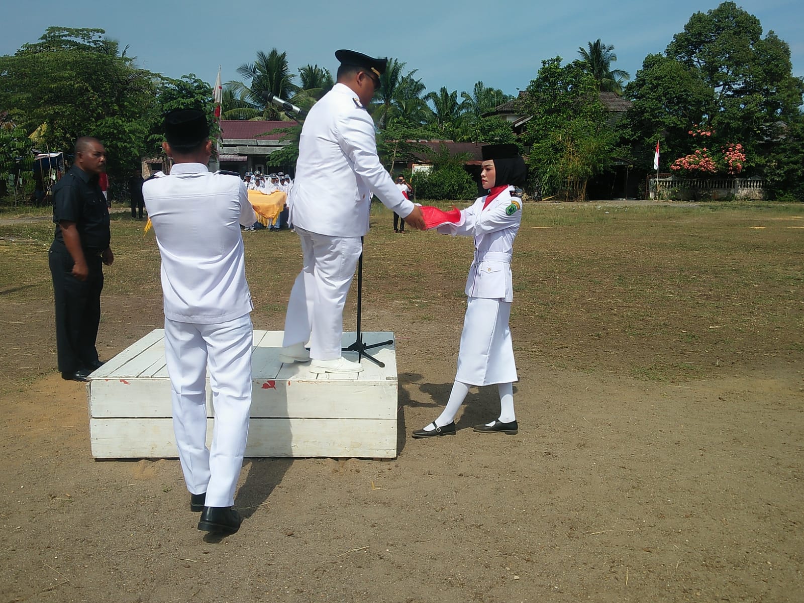 Camat Halongonan Amir Hakim Siregar Sstp Msi Memberikan Bendera Merah Putih Untuk dikibarkan Kepada Penggerak Bendera Upacara HUT RI Ke 77. Beritasore/Ist