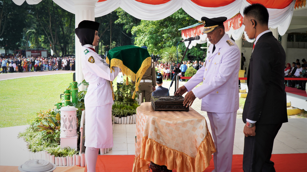 Plt  Bupati Langkat H Syah Afandin menerima bendera pada upacara peringatan detik-detik Proklamasi Kemerdekaan HUT RI ke-77 tahun, di Alun-alun T Amir Hamzah Stabat, Langkat, Rabu (17/8/2022). beritasore/ist
