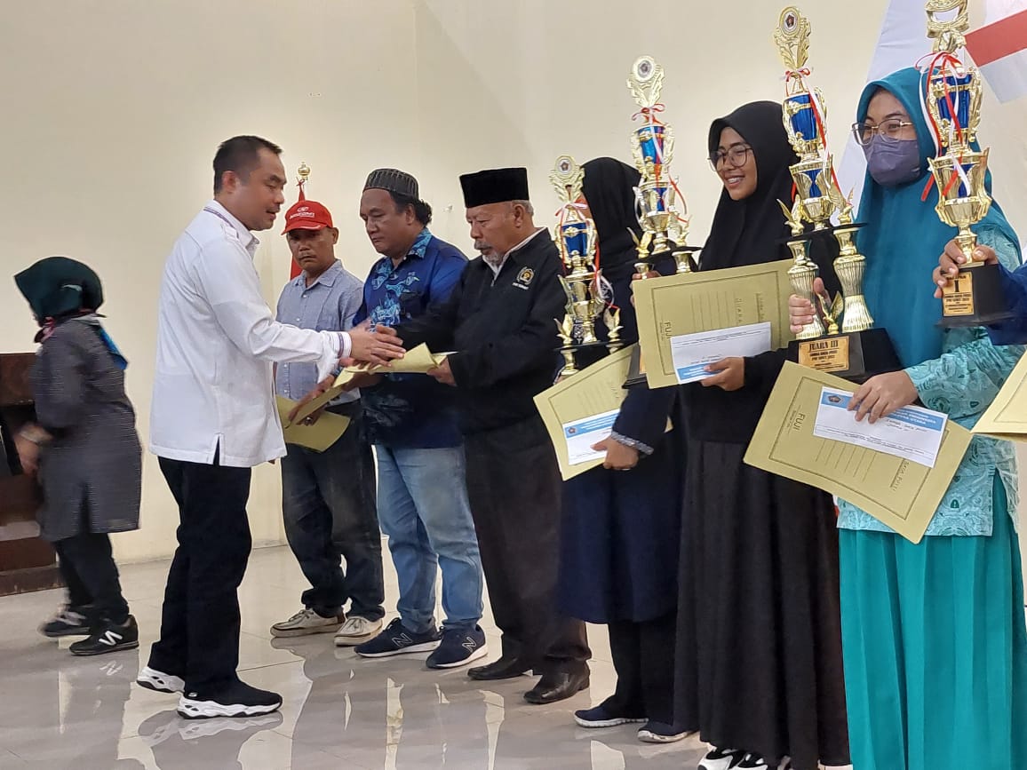 Ketua PWI Sumut H Farianda Putra Sinik menyerahkan hadiah kepada pemenang lomba baca puisi dan karya tulis di Kantor PWI Sumut Jalan Adinegoro Medan Sabtu (27/8/2022) malam. beritasore/ist