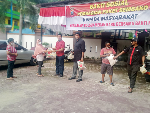 Kanit Reskrim Polsek Medan Baru AKP .Martua Manik SH MH di dampingi pemilik bakti Music saat membagikan sembako di halaman Polsek Medan Baru. beritasore/Ist