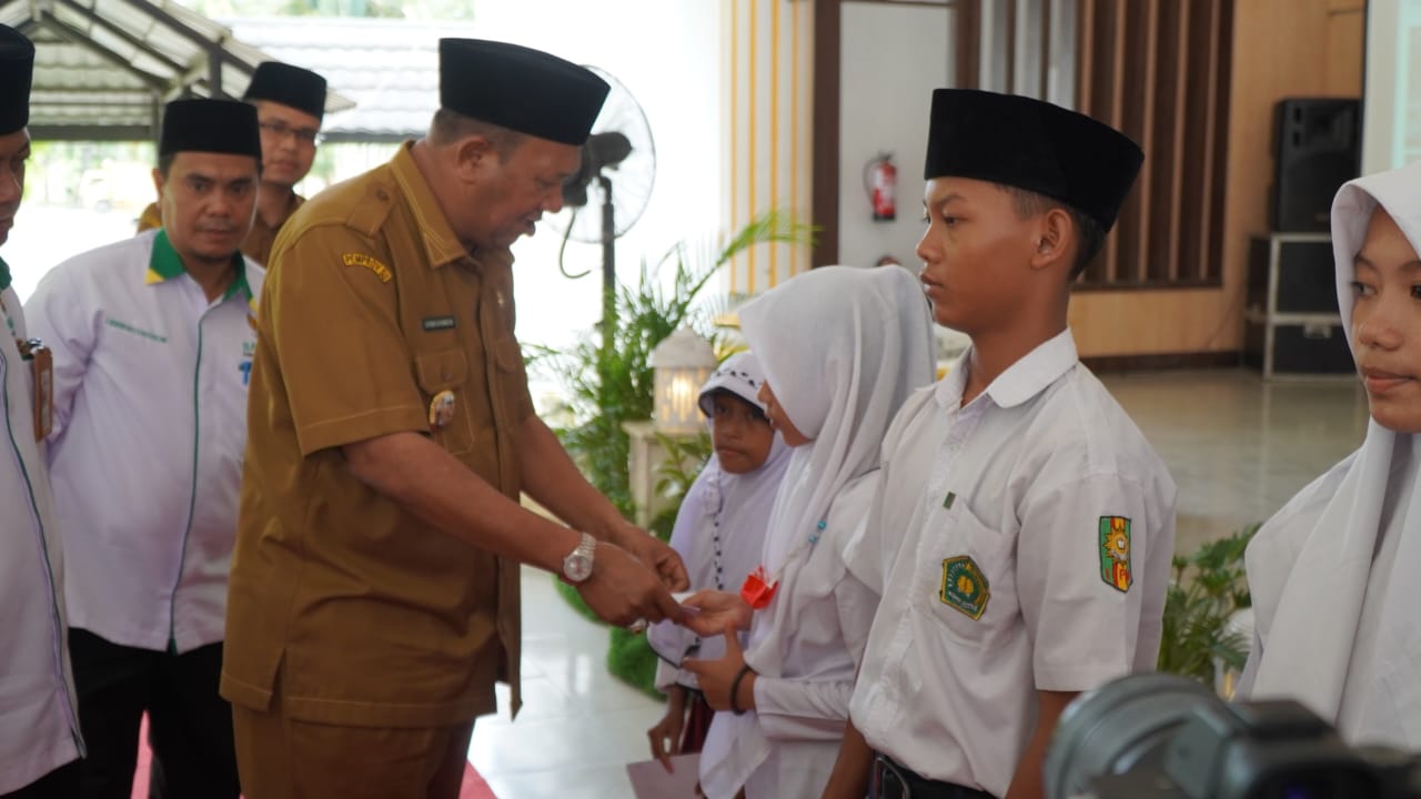 Plt Bupati Langkat menyerahkan zakat kepada siswa  di Jentera Malay Rumah Dinas Bupati Langkat, Stabat, Senin (29/8/2022). beritasore/ist