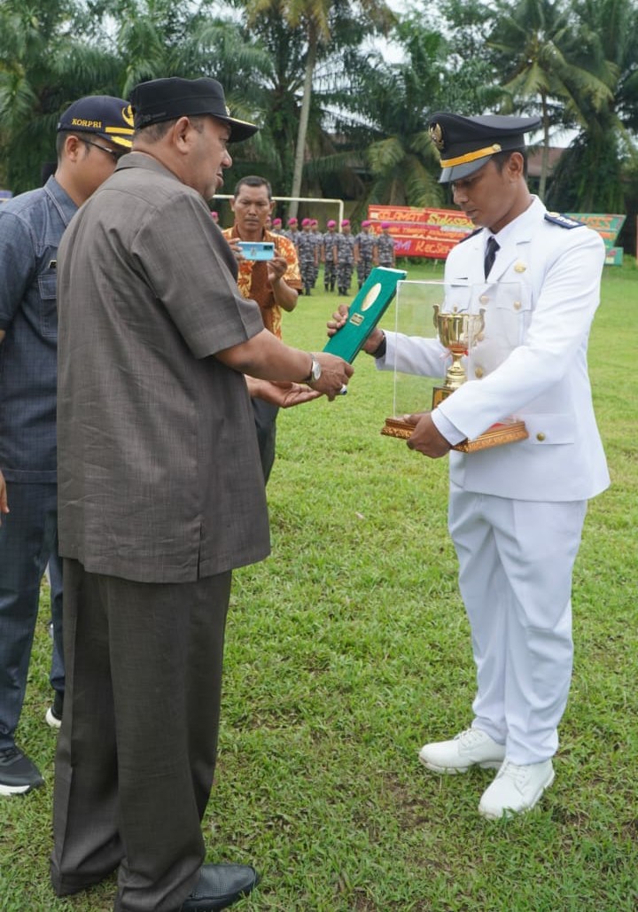 Plt  Bupati Langkat H Syah Afandin SH menyerahkan tunggul kecamatan terbaik  2022 tingkat Kab.Langkat kepada Camat Sei Lepan M Iqbal  di Lapangan Venus Komplek Pertamina P.Brandan Kec. Sei Lepan, Langkat, Kamis (8/9/2022). beritasore/ist