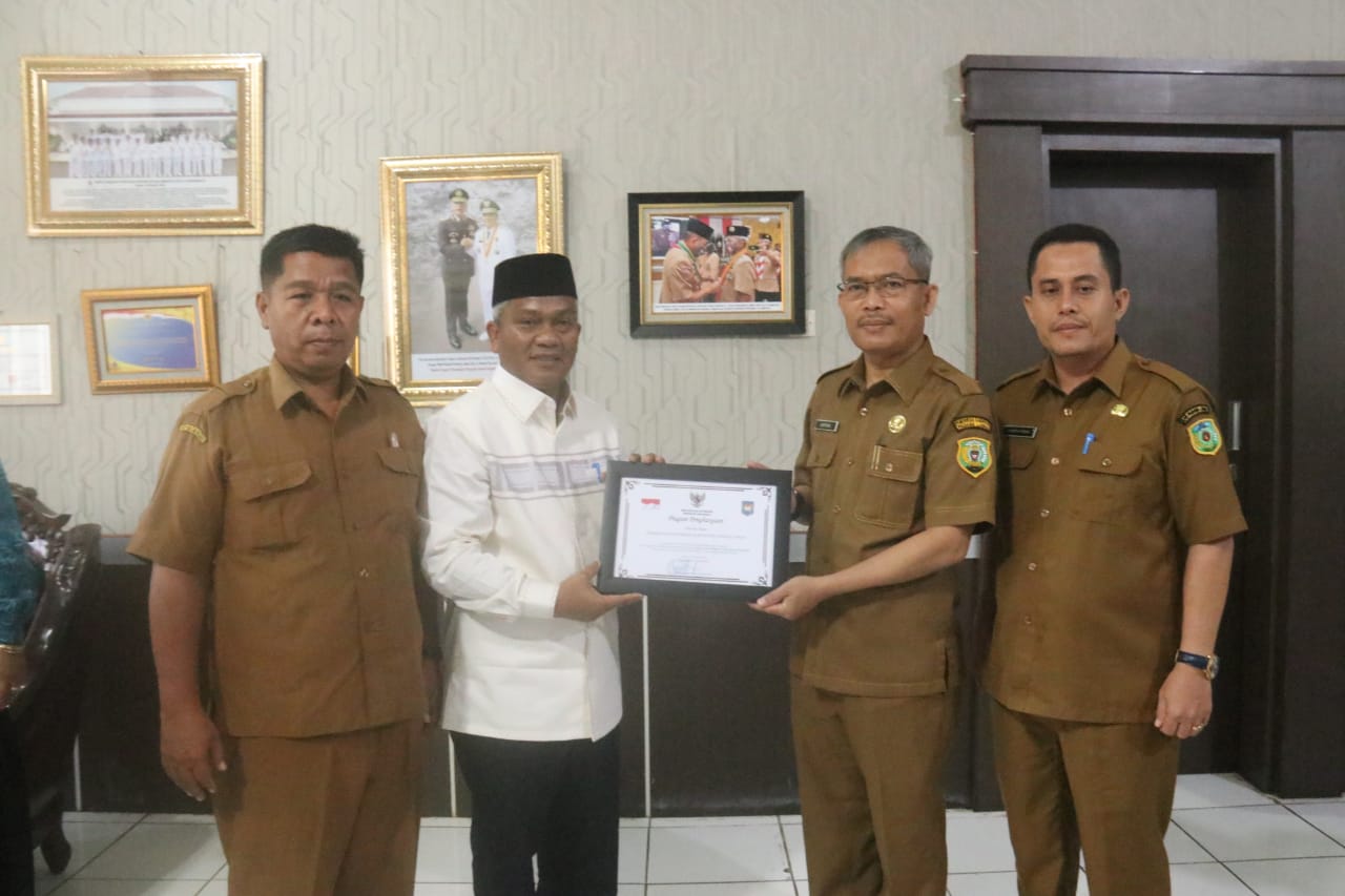 Plt Bupati Palas drg Ahmad Zarnawi Pasaribu CHt MM MSi dan Sekda Palas Arpan Nasution didampingi Kakan Kesbangpol, Alhaji Alamsyah Siregar, menerima piagam penghargaan dari Kemendagri. Selasa (13/9). Beritasore/ist