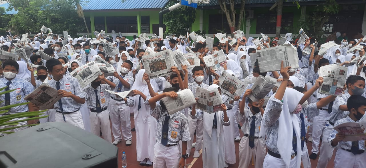 Para Pelajar SMP Negeri 1 Stabat, Langkat  mengikuti kegiatan Kampanye Gemar Membaca Koran Milenial yang dilaksanakan Serikat Perusahaan Pers Sumut di Halaman sekolah mereka , Kamis(15/9/2022).
