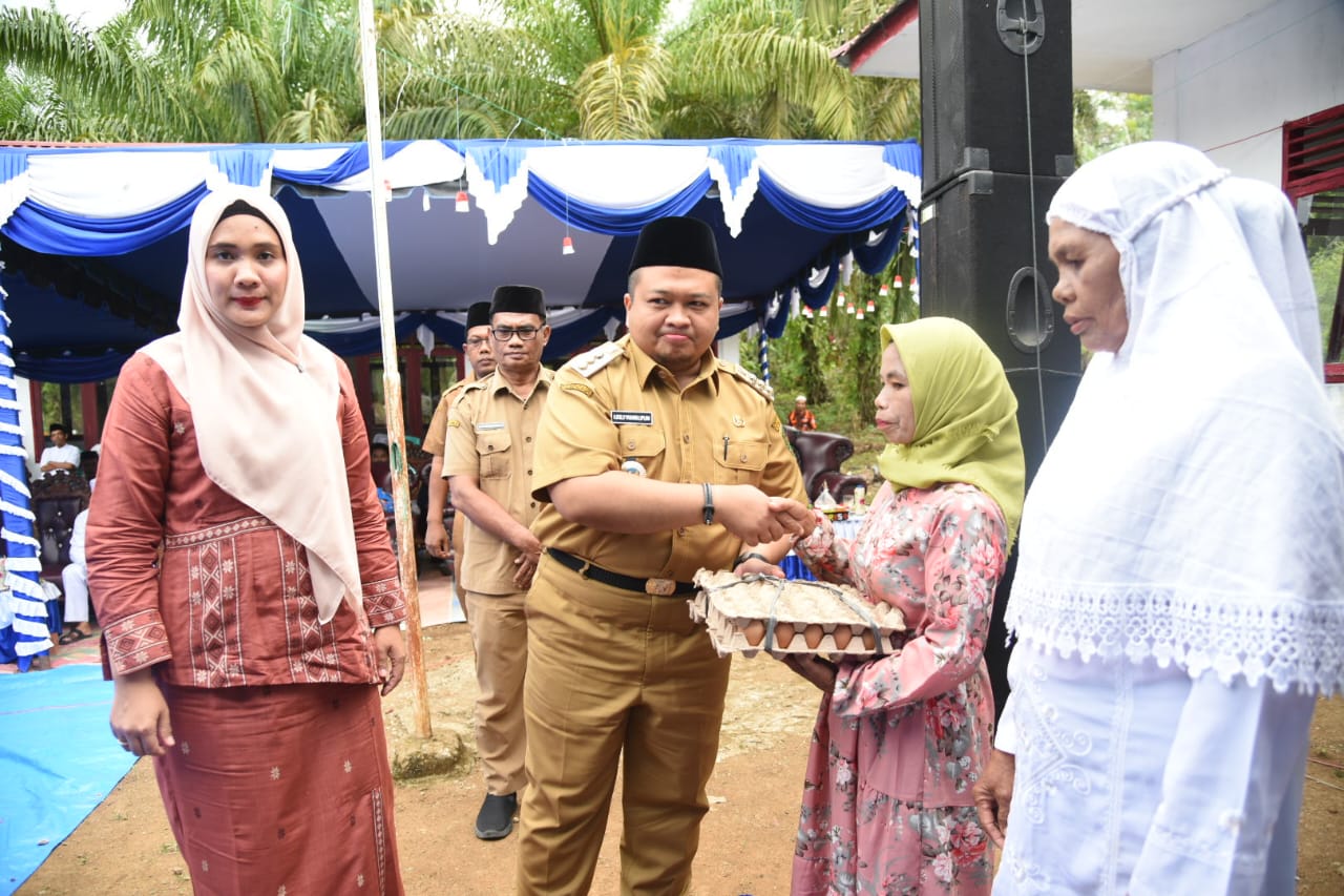 Bupati Tapanuli Selatan, Dolly Pasaribu dengan Ketua TPP PKK Tapsel, Ny Rosalina Pasaribu ketuka menyerahakan sembako kepada masyarakat Lanjut Usia (Lansia) di Desa Sihuik-kuik, Selasa (20/9). beritasore/Birong RT