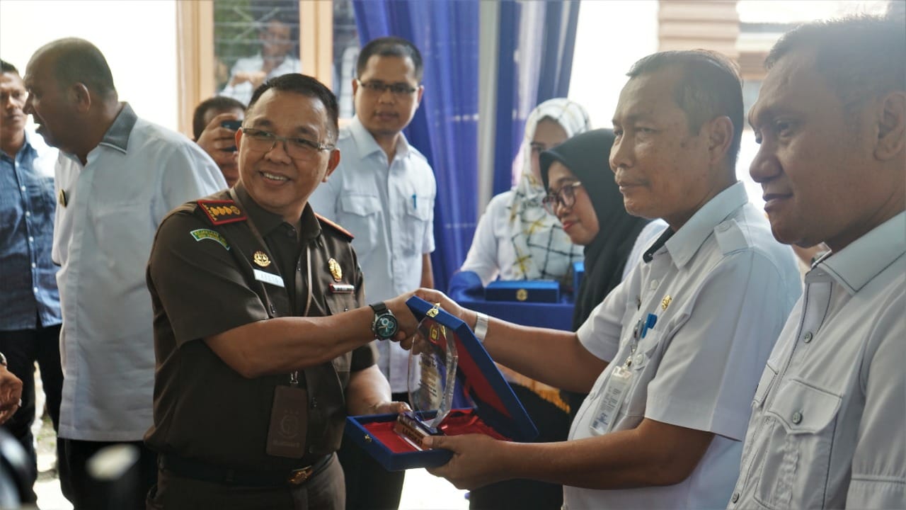 Plt Bupati Langkat H Syah Afandin SH serahkan penghargaan kepada capaian realisasi target pendapatan asli daerah (PAD) Kabupaten Langkat 2021, di Halaman Kantor Bapenda Langkat, Stabat, Rabu (21/9/2022). beritasore/ist