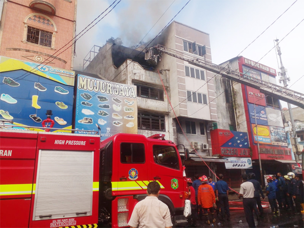 Personil Dinas Pencegah dan Pemadam Kebakaran Pemko Medan sedang memadamkan kobaran api saat terjadinya kebakaran di toko sepatu di Jl. Sutomo Kelurahan Gang Buntu Kecamatan Medan Timur, Selasa (11/10) sekira pukul 07:20. beritasore/Andi Aria Tirtayasa