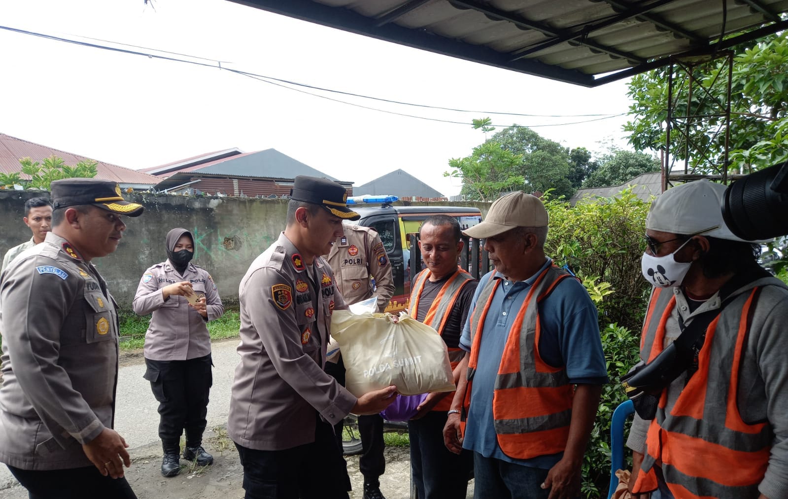 Wakapolrestabes Medan AKBP. DR.Yudi Heri Setiawan, didampingi Kapolsek Medan Baru Kompol Ginanjar Fitriadi, saat memberikan paket sembako kepada perwakilan petugas Pos Kamling