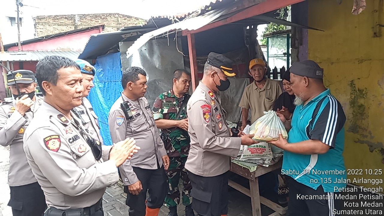 Teks.Plh Kapolsek Medan Baru Kompol Tomy yang di dampingi Kanit Samapta Iptu Carles.BA Siregar saat memberikan bantuan sembako kepada warga yang terdampak banjir di jalan Air Langga