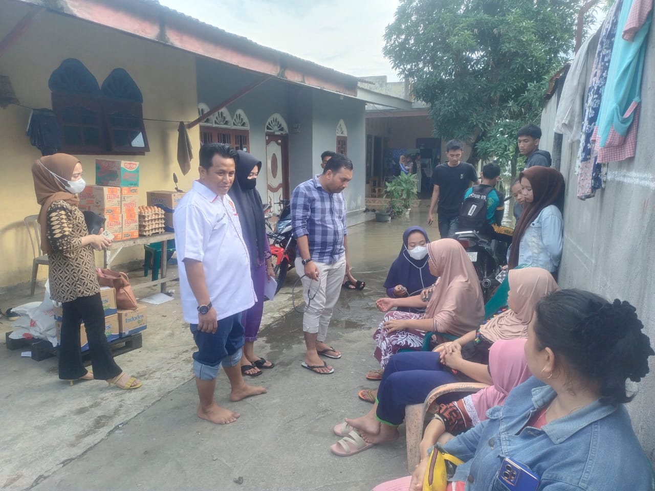 Teks Foto: Ketua Gemira Deliserdang Muhammad Hendrik bersama tim medis saat mengecek kesehatan warga korban banjir dan memberikan bantuan sembako. (Foto: Edward Limbong).