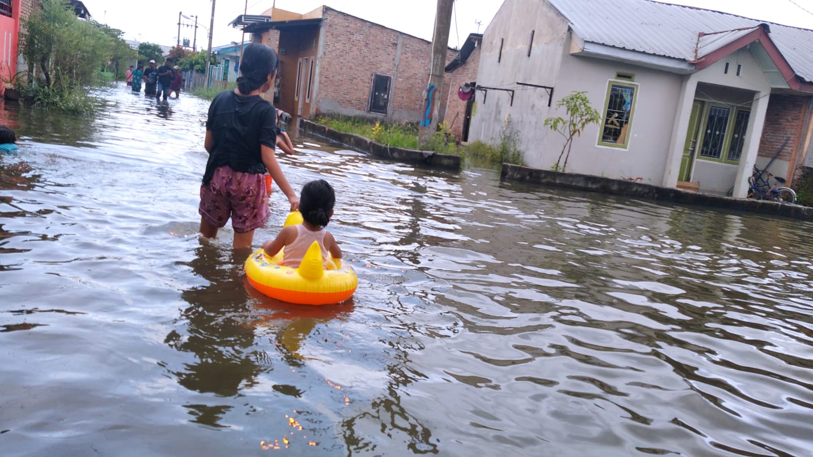 Berita Sore/Andi Aria Tirtayasa: Anak-anak bermain-main di genangan banjir yang merendam pemukiman warga Komplek Perumahan TKBM Upaya Karya Pelabuhan Belawan Kelurahan Sei Mati Kecamatan Medan Labuhan, Minggu (20/11).
