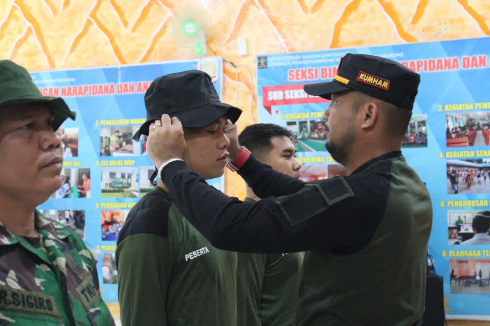 Kepala Lapas Siborongborong Parlindungan Sianturi menyematkan topi latihan kepada Petugas Pemasyarakatan Lapas Siborongborong saat upacara pembukaan latihan Pembinaan Fisik, Mental dan Disiplin (FMD) di Aula Lapas Siborongborong, Rabu (23/11). /ist