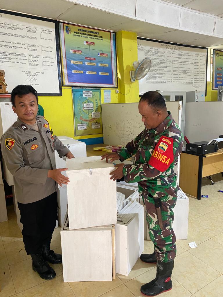Giat Bhabinkamtibmas Polsek Labuhan Ruku BRIPTU Nicolas Lintong Situmorang monitiring/ cek kotak dan bilik suara di Kantor Balai Desa Perkebunan Sei Balai Kec Sei Balai Kabuoaten Batu Bara Sabtu (12/11-2022).beritasore/alirsyah