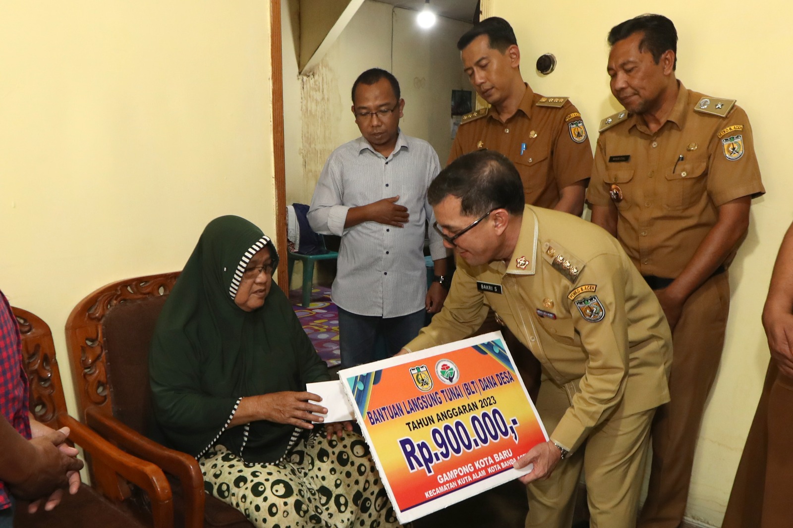 Pj.Wali Kota Banda Aceh Bakri Siddiq menyerahkan secara simbolis Bantuan Langsung Tunai (BLT) kepada salah seorang warga Gampong Kuta Baru Kecamatan Kuta Alam, Banda Aceh, Selasa (07/03/23). (Foto:T.Mansursyah)