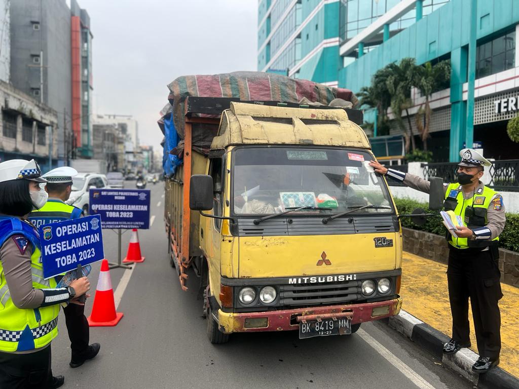 Berita Sore/Andi Aria Tirtayasa: Personel Satlantas Polrestabes Medan membagi-bagikan brosur tertib berlalulintas dan sticker kepada pengemudi angkutan saat melakukan Operasi Keselamatan Toba 2023 di Jl. Irian Barat Medan, Kamis (9/3).