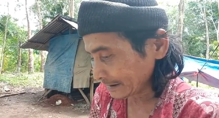Teks foto: Rusli Mais, 57, menderita sesak nafas, hidup bersama dua anaknya di gubuk 2 × 3 meter di tengah kebun karet milik warga.