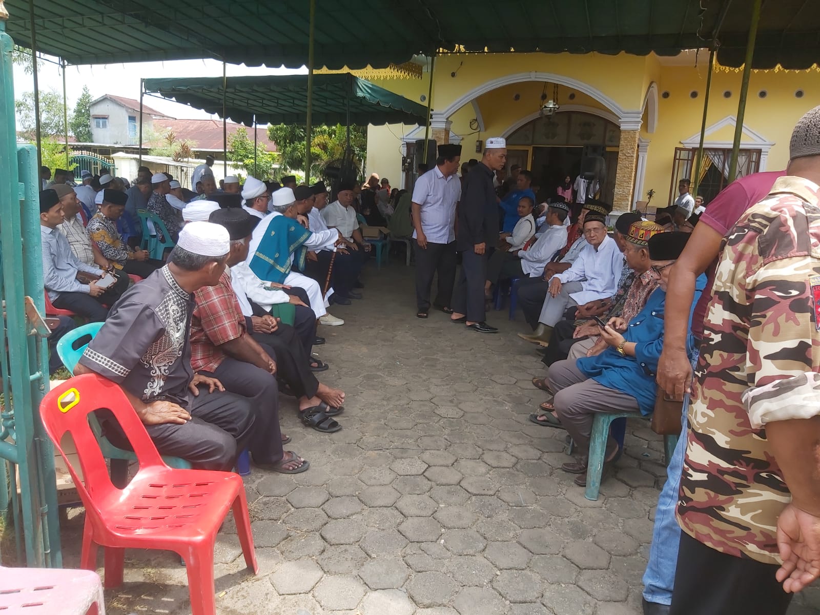 Teks Foto/Beritasore/Boy Aprizal : Plt Bupati Langkat H Syah Afandin saat melayani pelayat di rumah duka Jl Stasiun Kereta Api Kelurahan Brandan Timur Kec.Babalan, Langkat, Kamis(16/3/2023)