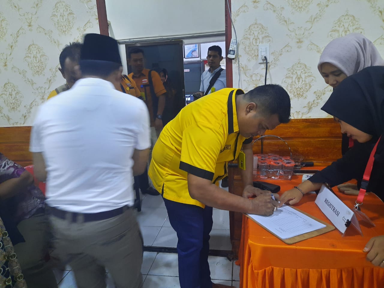 Keterangan poto: Ketua Hanura Binjai menandatangani daftar apsen di kantor KPU(Foto: Nazelian Tanjung).
