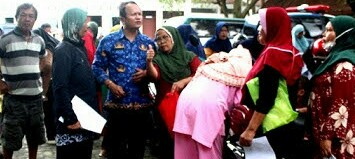 Kabid Rehsos dan Dayasos Dinsos P3A Risbon Sinaga memberikan penjelasan ketika ratusan warga miskin atau prasejahtera penerima BPNT mendatangi kantor Dinsos P3A Pemko Pematangsiantar, Jl. Dahlia, Senin (22/5), untuk meminta undangan penerimaan bantuan beras melalui Kantor Pos.(Foto: Edoard Sinaga).