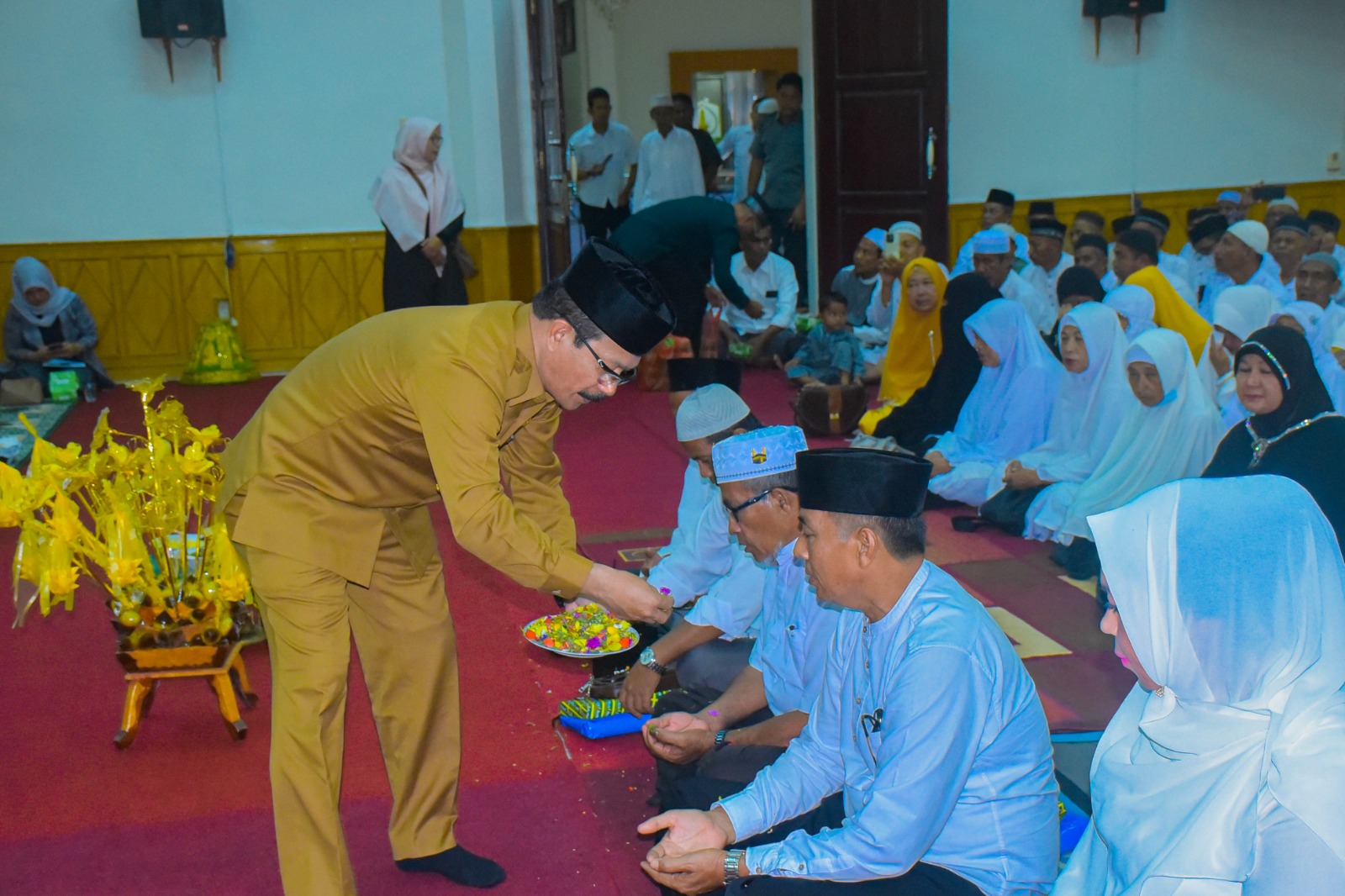 Teks Foto : Pejabat (Pj) Pemerintahan Kabupaten Aceh Tamiang , Dr. Drs. Meurah Budiman, SH, MH, saat melakukan peusijuk kepada calon Jama’ah Haji di Aula Setdakab setempat, Selasa (23/5).
