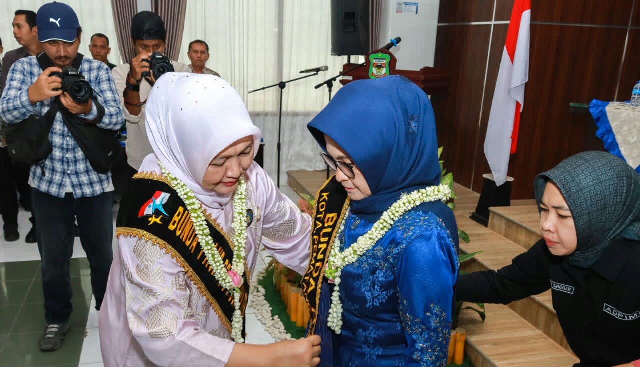 Keterangan foto: Bunda PAUD Provsu Ny. Nawal Lubis Edy Rahamayadi (kiri) mengukuhkan Wali Kota Susanti Dewayani (kanan) menjadi Bunda PAUD Kota Pematangsiantar di ruang serbaguna BP3D Pemko, Jl. Merdeka, Senin (29/5).(ist).