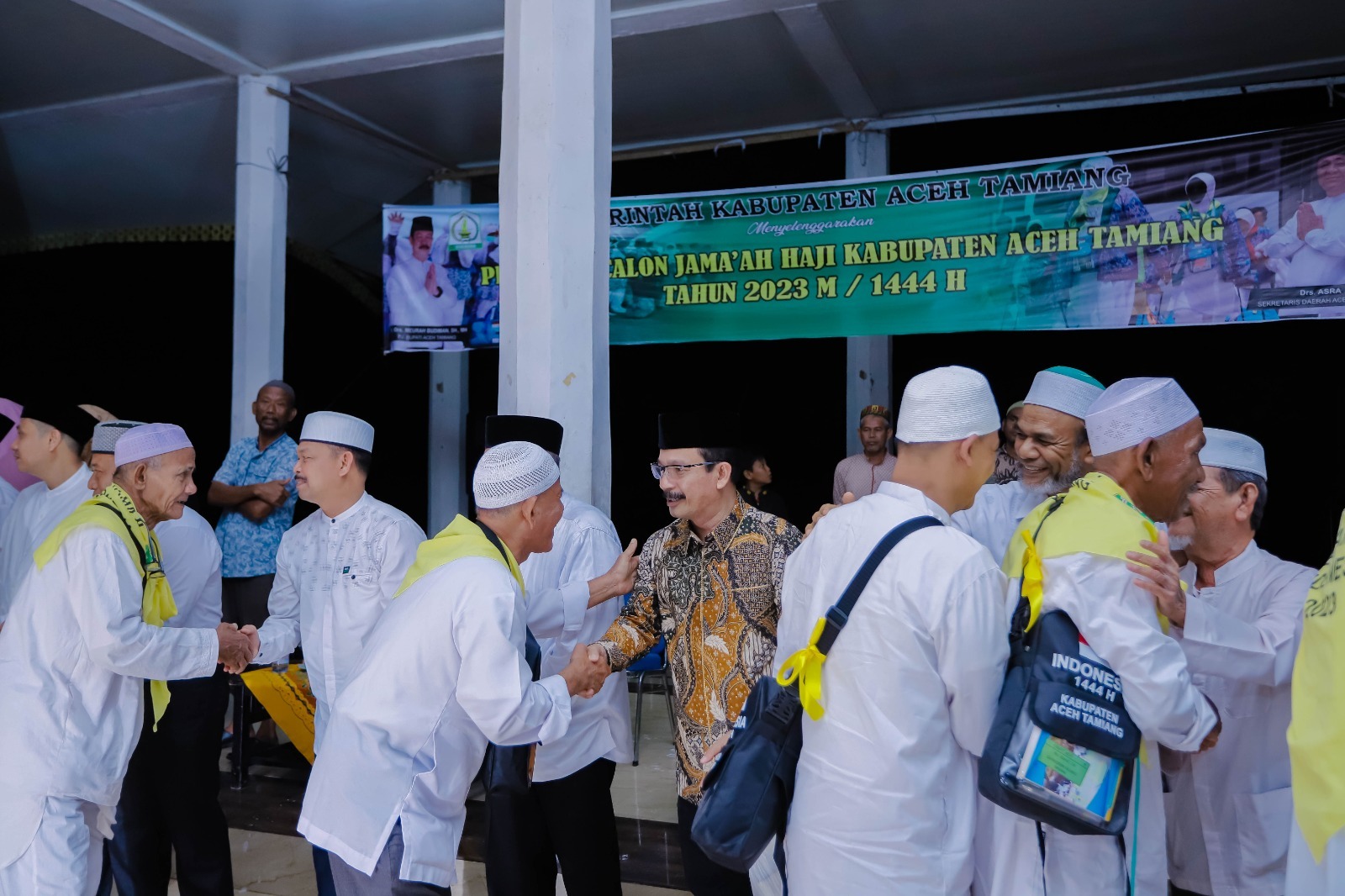 Teks Foto : Pj. Bupati Aceh Tamiang, Dr. Drs. Meurah Budiman, SH, MH saat memberikan selamat kepada calon jamaah haji kloter 10.