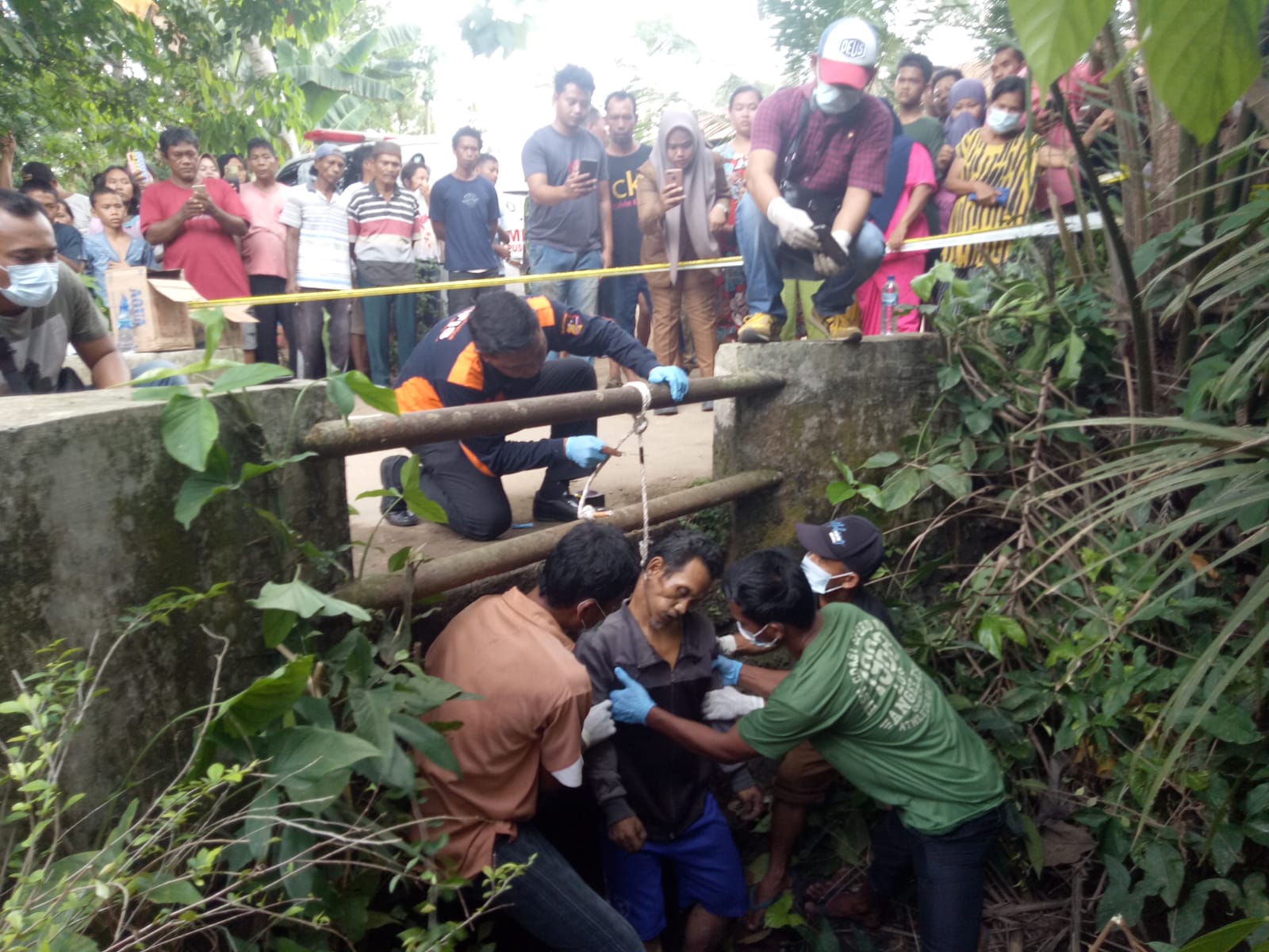 Teks fhoto: Junaidi (52) warga Dusun VII Desa Tanjung Parapat Kecamatan Laut Tador Kabupaten Batu Bara ditemukan warga sudah tidak bernyawa tergantung di jembatan Jln.Dusun VII Desa Tanjung Parapat Selasa (20/6-2013).beritasore/alirsyah