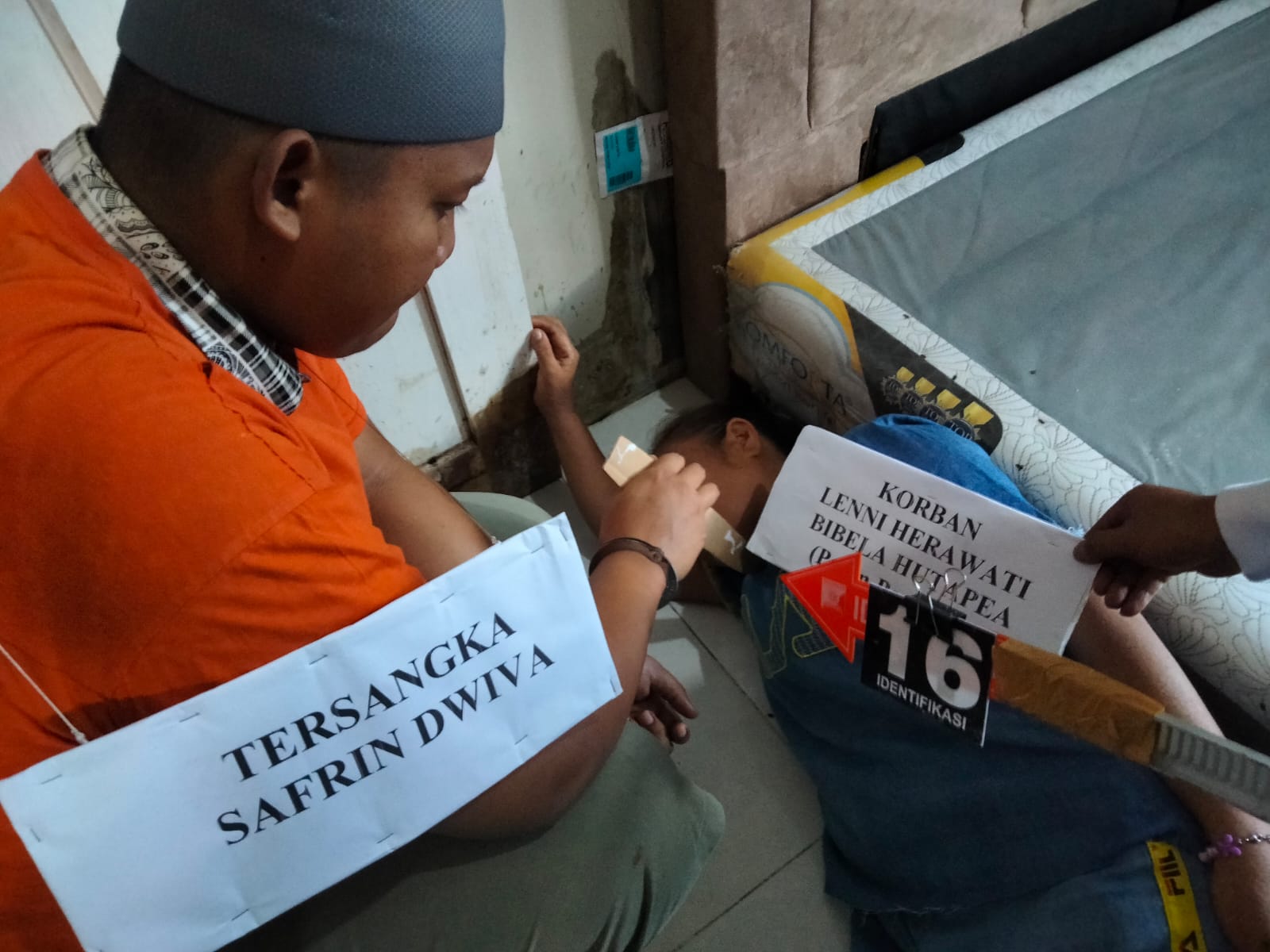  Tersangka SD memperagakan penusukan (menikam) korban (peran pengganti) saat dilakukannya rekostruksi pembunuhan ibu dan anaknya di rumah korban, Senin (5/5).(ist).