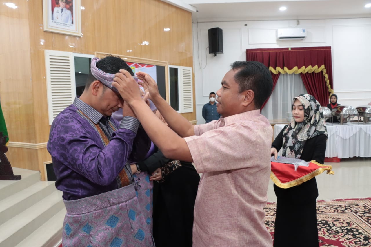 Teks foto:Bupati Serdang Bedagai H Darma Wijaya, memasangkan pakain Teluk belanga kepada Mayhardi Indra Putra= SH, MH, Kepala Kejari Sergai yang baru, di Aula Sultan Serdang, Senin, malam 28-08-2023(Beritasore-Azwen)