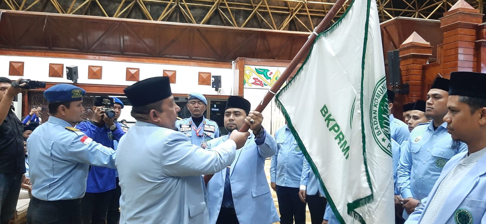 Ketua DPP BKPRMI H.Said Aldi Al Idrus menyerahkan pataka kepada Ketua Umum DPW BKPRMI Aceh, Mulia Rahman saat pelantikan pengurus periode 2023-2027 di Anjong Mon Mata Banda Aceh, Selasa (29/08/23) malam. (Foto: T.Mansursyah)