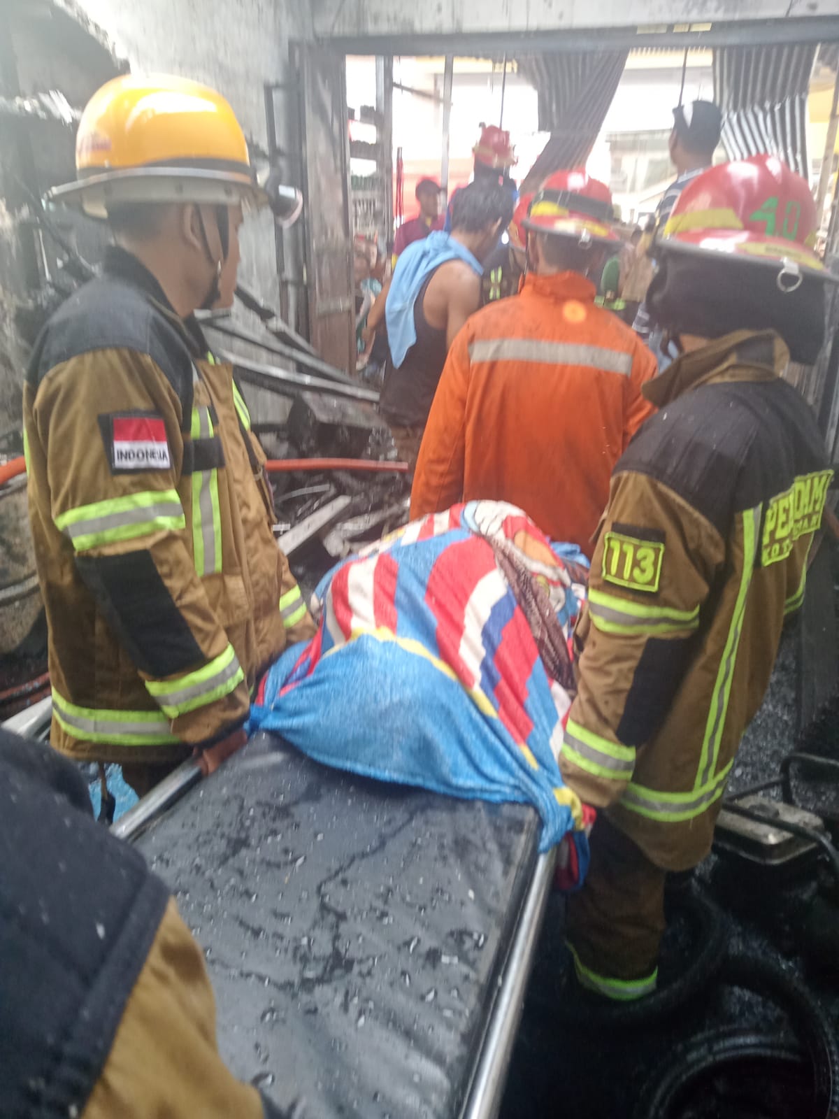 Berita Sore/Andi Aria Tirtayasa Petugas Dinas Pencegah dan Pemadam Kebakaran Pemko Medan mengevakuasi jasad korban kebakaran di rumah merangkap bengkel sepedamotor di Jl. Marelan IX Lingkungan VI Kelurahan Tanah Enam Ratus Kecamatan Medan Marelan, Rabu (30/8).